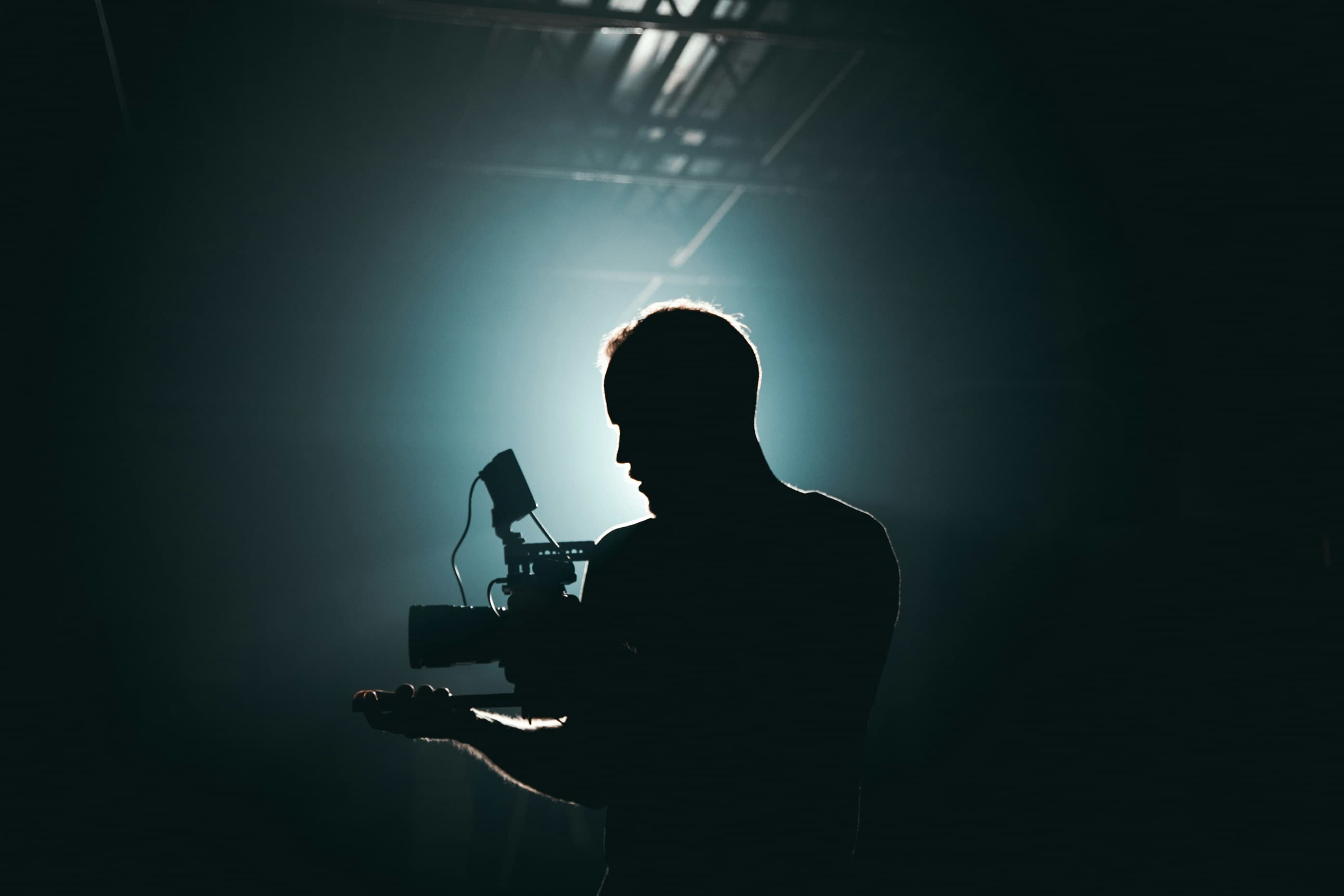 A silhouetted camera operator backlit on a production set